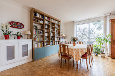 Cette image montre une salle à manger traditionnelle avec un mur blanc, un sol en bois brun et aucune cheminée.