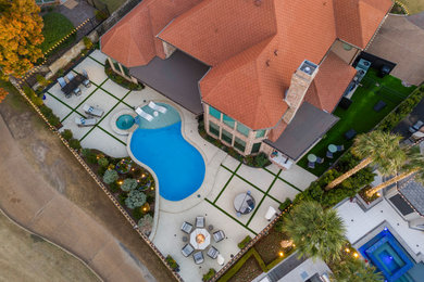 Inspiration for a huge modern backyard stamped concrete patio kitchen remodel in Dallas with a roof extension