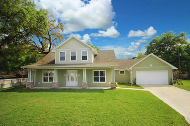 Photo of a mid-sized arts and crafts two-storey green house exterior in Orlando with mixed siding, a gable roof and a shingle roof.