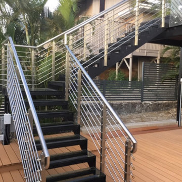 Outdoor staircase with stainless steel railing and glass tread