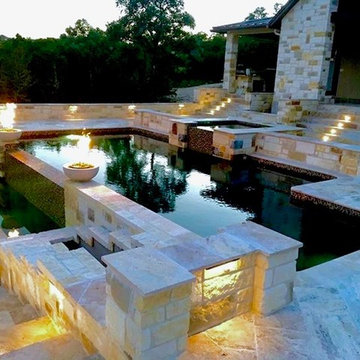 Elevated travertine pool with fire bowls