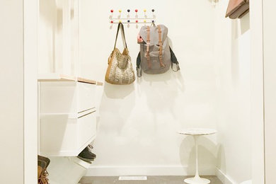 Example of a mid-sized trendy gender-neutral carpeted and gray floor walk-in closet design in Salt Lake City with glass-front cabinets and white cabinets