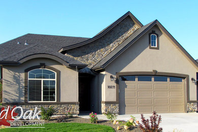 Large traditional brown two-story stucco exterior home idea in Boise