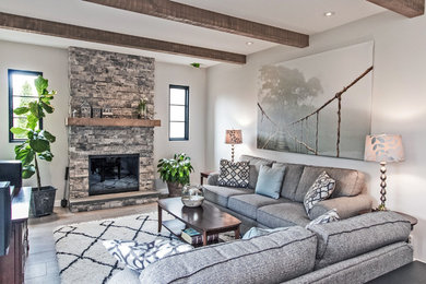 Design ideas for a mid-sized transitional open concept living room in Philadelphia with white walls, a standard fireplace, a stone fireplace surround, no tv, grey floor and ceramic floors.