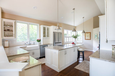 Large transitional u-shaped medium tone wood floor, brown floor and vaulted ceiling eat-in kitchen photo in Other with a farmhouse sink, shaker cabinets, white cabinets, quartz countertops, white backsplash, porcelain backsplash, stainless steel appliances, an island and beige countertops