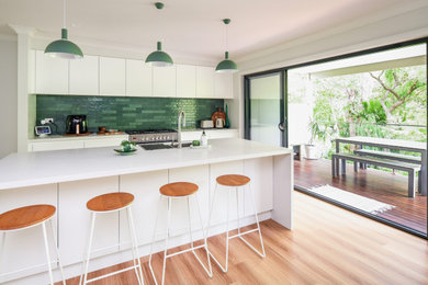 This is an example of a modern single-wall eat-in kitchen in Other with green splashback and with island.