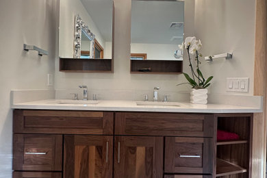 Example of a mid-sized 1950s master beige tile and porcelain tile porcelain tile, white floor and double-sink bathroom design in New York with shaker cabinets, dark wood cabinets, an undermount tub, a one-piece toilet, white walls, an undermount sink, quartz countertops, white countertops, a niche and a built-in vanity