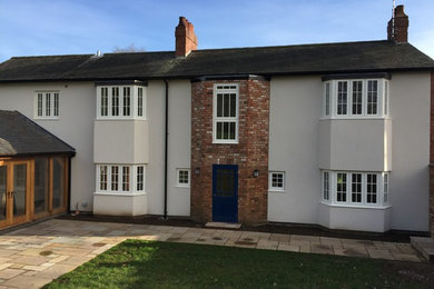 Photo of a multi-coloured classic two floor house exterior in Other with mixed cladding and a pitched roof.