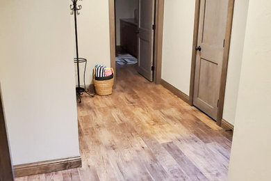 Large mountain style look-out vinyl floor and brown floor basement photo in Other with a bar and beige walls