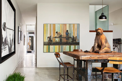 Design ideas for an eclectic dining room in Los Angeles with white walls and concrete floors.