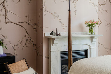 Example of a transitional medium tone wood floor and brown floor bedroom design in Boston with pink walls and a standard fireplace
