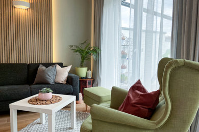 Geräumiges, Offenes Wohnzimmer mit grüner Wandfarbe, braunem Holzboden und Wandpaneelen in München