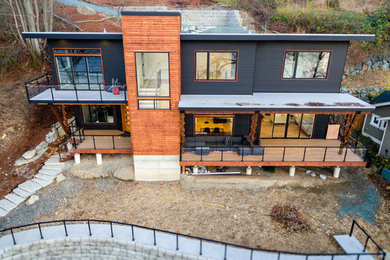 Inspiration for a large modern gray two-story concrete fiberboard house exterior remodel in Seattle with a shed roof