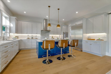 Large beach style u-shaped medium tone wood floor and multicolored floor open concept kitchen photo in San Francisco with an undermount sink, shaker cabinets, white cabinets, quartz countertops, white backsplash, ceramic backsplash, stainless steel appliances, an island and white countertops
