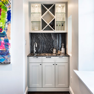 ニューヨークの小さいトランジショナルスタイルのおしゃれなウェットバー (シェーカースタイル扉のキャビネット、白いキャビネット、濃色無垢フローリング、アンダーカウンターシンク、御影石カウンター、黒いキッチンパネル、石スラブのキッチンパネル) の写真