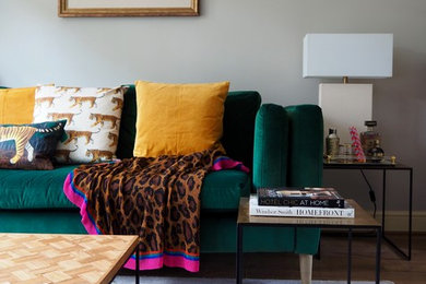 Inspiration for a mid-sized eclectic formal and enclosed laminate floor and brown floor living room remodel in Surrey with gray walls, a standard fireplace, a concrete fireplace and a tv stand