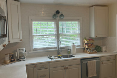 Example of a small cottage chic l-shaped laminate floor and gray floor eat-in kitchen design in Other with an undermount sink, shaker cabinets, beige cabinets, granite countertops, white backsplash, ceramic backsplash, stainless steel appliances, no island and multicolored countertops