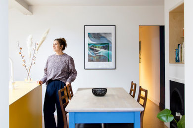 This is an example of a small scandi open plan dining room in London with multi-coloured walls, cork flooring and a ribbon fireplace.