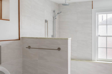 Photo of a mid-sized contemporary 3/4 bathroom in Boston with a curbless shower, an urinal, white tile, porcelain tile, white walls, porcelain floors, an integrated sink, solid surface benchtops, white floor, an open shower and green benchtops.