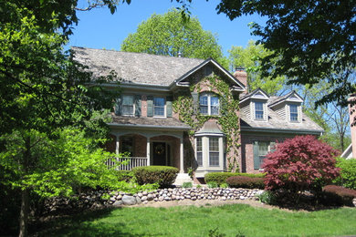 Mid-sized elegant red two-story brick exterior home photo in Chicago with a hip roof