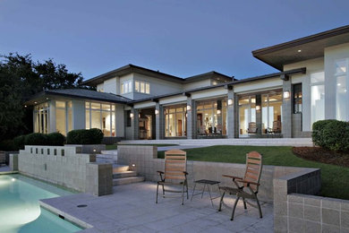 Large contemporary gray two-story stucco exterior home idea in Austin