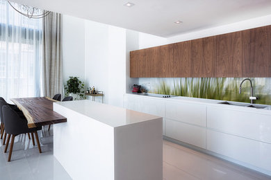 Photo of a mid-sized contemporary kitchen in Brisbane with a drop-in sink, solid surface benchtops, green splashback, glass sheet splashback, stainless steel appliances, porcelain floors, with island and white floor.