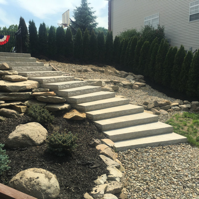 Brought functionality to this side yard by adding this ledgestone step system from Unilock, natural sandstone, river rock and low maintenance planting.