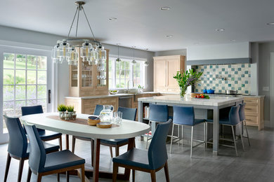 Inspiration for a large transitional u-shaped porcelain tile eat-in kitchen remodel in New York with a farmhouse sink, recessed-panel cabinets, light wood cabinets, quartzite countertops, gray backsplash, ceramic backsplash, paneled appliances and an island