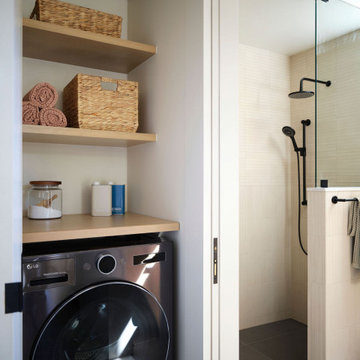 Compact ADU Laundry Niche and Modern Walk-In Shower with Matte Black Fixtures