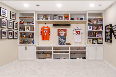 Example of a large classic underground carpeted and beige floor basement game room design in Minneapolis with beige walls, a standard fireplace and a stone fireplace