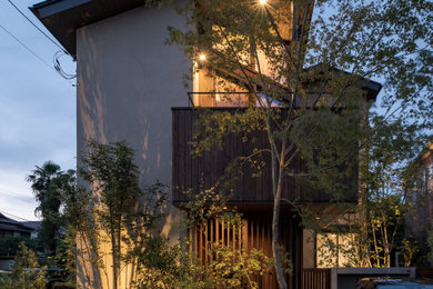 Ejemplo de fachada de casa beige y marrón de dos plantas con revestimiento de estuco, tejado a dos aguas, tejado de metal y panel y listón