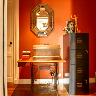 Idées déco pour une petite entrée éclectique avec un couloir, un mur orange, un sol en bois brun, une porte simple, une porte blanche et un sol marron.