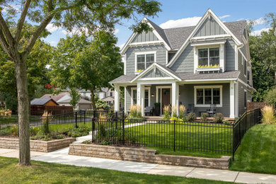This is an example of a mid-sized arts and crafts two-storey grey house exterior in Minneapolis with mixed siding, a gable roof, a shingle roof, a black roof and clapboard siding.
