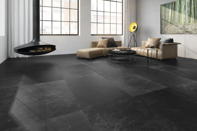 Large contemporary open plan living room in Other with white walls, concrete flooring, a hanging fireplace and black floors.