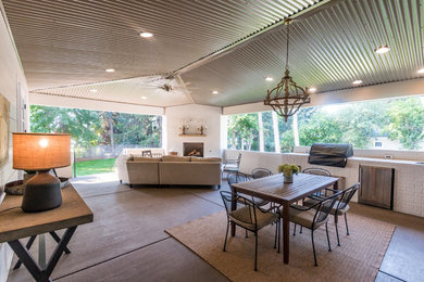 Inspiration for a large transitional backyard concrete paver patio remodel in Other with a fire pit and a roof extension
