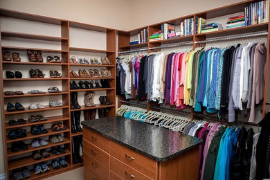 Mid-sized traditional women's walk-in wardrobe in Denver with open cabinets, medium wood cabinets and carpet.