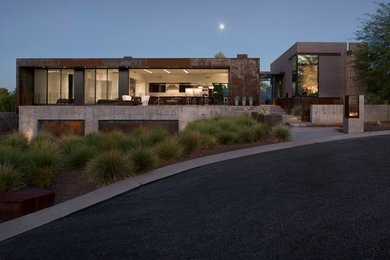 Mid-sized modern split-level grey exterior in Phoenix with metal siding and a flat roof.