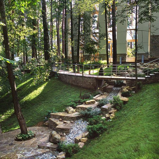 Aménagement d'un jardin à la française montagne l'été avec une entrée ou une allée de jardin et une exposition partiellement ombragée.