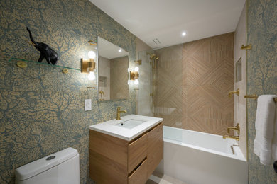 Tub/shower combo - master brown tile and porcelain tile porcelain tile, beige floor, single-sink and wallpaper tub/shower combo idea in DC Metro with flat-panel cabinets, light wood cabinets, a one-piece toilet, multicolored walls, an undermount sink, quartz countertops, a hinged shower door, white countertops, a niche and a floating vanity