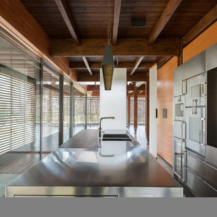 Photo of a large contemporary galley separate kitchen in Milan with a double-bowl sink, beaded inset cabinets, stainless steel cabinets, stainless steel benchtops, stainless steel appliances, marble floors and with island.