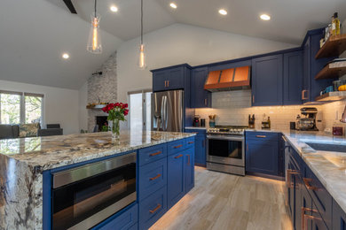 Example of a mid-sized transitional l-shaped porcelain tile, multicolored floor and vaulted ceiling eat-in kitchen design in Indianapolis with an undermount sink, shaker cabinets, blue cabinets, quartzite countertops, white backsplash, subway tile backsplash, stainless steel appliances and an island