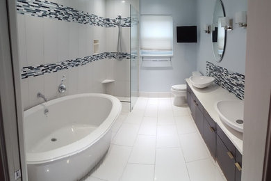 Bathroom - large contemporary master blue tile, white tile and matchstick tile porcelain tile and white floor bathroom idea in Houston with flat-panel cabinets, dark wood cabinets, a one-piece toilet, gray walls, a vessel sink and quartzite countertops