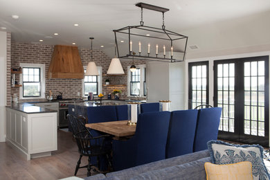 Great room - mid-sized coastal light wood floor great room idea in Boston with gray walls, a standard fireplace and a stone fireplace