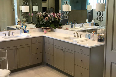 This is an example of a large contemporary master bathroom in Orlando with recessed-panel cabinets, grey cabinets, solid surface benchtops, white benchtops, a freestanding tub, a curbless shower, an undermount sink and white floor.