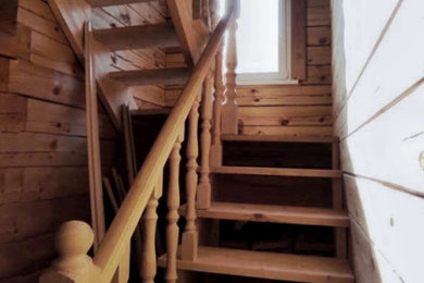 На фото: п-образная деревянная лестница среднего размера в классическом стиле с деревянными ступенями, деревянными перилами и деревянными стенами с
