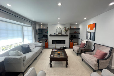 サンフランシスコにある高級な中くらいなコンテンポラリースタイルのおしゃれなLDK (白い壁、濃色無垢フローリング、標準型暖炉、石材の暖炉まわり、グレーの床) の写真