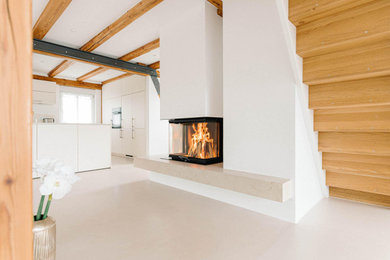 他の地域にあるコンテンポラリースタイルのおしゃれなLDK (白い壁、薪ストーブ、石材の暖炉まわり、ベージュの床) の写真