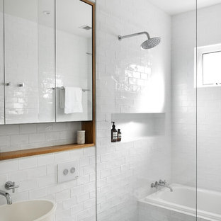 Photo of a contemporary 3/4 bathroom in Sydney with flat-panel cabinets, medium wood cabinets, a drop-in tub, a curbless shower, white tile, subway tile, white walls, a vessel sink, grey floor, an open shower and white benchtops.