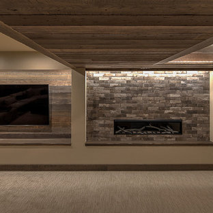 Diseño de sótano en el subsuelo rural, grande, con paredes marrones, moqueta, chimeneas suspendidas, marco de chimenea de baldosas y/o azulejos y suelo beige