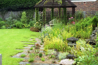 Design ideas for a mid-sized traditional partial sun backyard landscaping in Kansas City for summer.